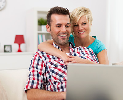 Couple reading on mortgage topics on PC